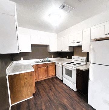 Hattiesburg apartment for rent - a kitchen with white appliances and wooden cabinets