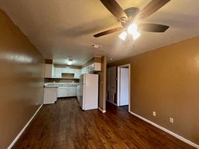 Hattiesburg apartment for rent - an empty living room and kitchen with a ceiling fan