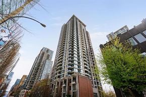 Vancouver apartment for rent - A tall residential building stands in the middle of a city street.