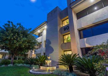 Thousand Oaks apartment for rent - A modern building with the number 90 on it is surrounded by greenery.