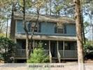 Raleigh house for rent - A house with a porch and a tree in front of it.