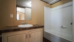 Royse City apartment for rent - A bathroom with a sink, mirror, and shower.