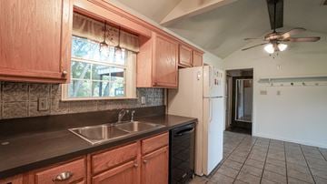 Royse City apartment for rent - A kitchen with wooden cabinets and a white fridge.