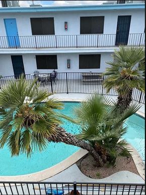 Las Vegas apartment for rent - a swimming pool with palm trees in front of a building