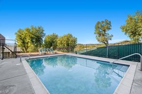 Fallbrook apartment for rent - a swimming pool with a fence around it and trees in the background