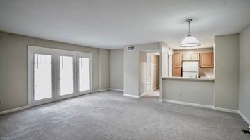 Raleigh apartment for rent - an empty living room with large windows and a kitchen