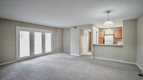 Raleigh apartment for rent - an empty living room with large windows and a kitchen