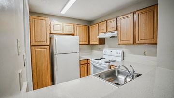 Raleigh apartment for rent - a kitchen with white appliances and wooden cabinets