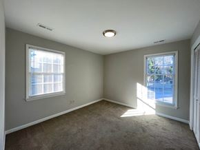 Raleigh house for rent - a empty room with two windows and a carpeted floor