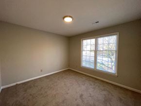 Raleigh house for rent - an empty living room with a window and carpet