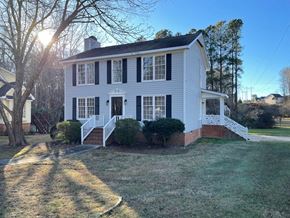 Raleigh house for rent - a white house with black shutters and a lawn and a tree