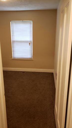 Pontiac apartment for rent - A room with a carpeted floor and a window with blinds.
