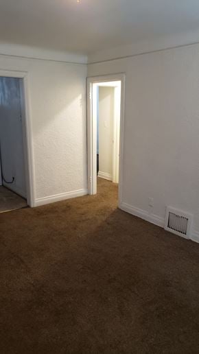 Pontiac apartment for rent - A room with a carpeted floor and a doorway leading to another room.