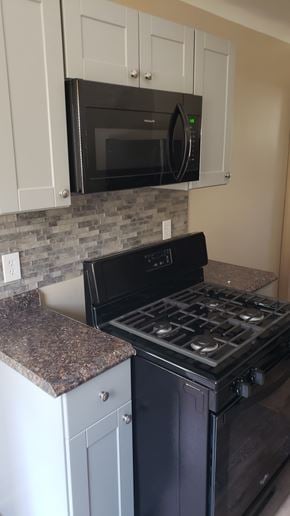 Pontiac apartment for rent - A black stove top oven sitting under a microwave.