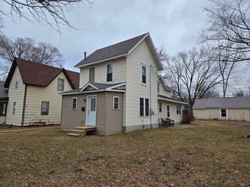 Menomonie house for rent - A two-story house with a white front and a brown roof.