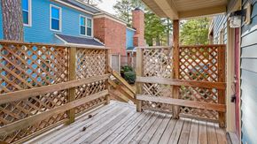 Raleigh apartment for rent - a deck with a blue house and a wooden fence