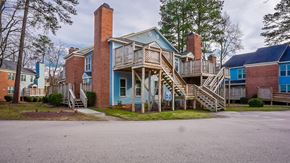 Raleigh apartment for rent - a blue house with stairs and a parking lot