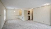 Raleigh apartment for rent - an empty living room with white walls and a kitchen