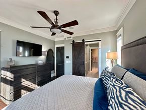 Greenville house for rent - a bedroom with a large bed and a ceiling fan
