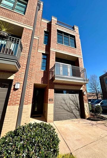 Greenville house for rent - a brick building with two garage doors and a balcony