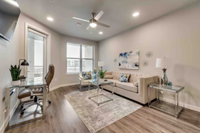Mckinney house for rent - a living room with a couch and a desk and a ceiling fan