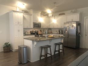 Aiken house for rent - a kitchen with white cabinets and a counter top