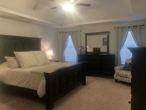 Aiken house for rent - the master bedroom has a king size bed and a dresser and chair
