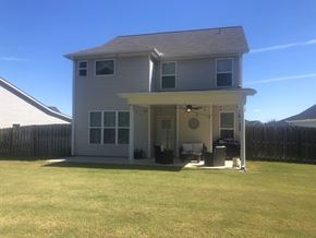 Aiken house for rent - a white house with a lawn in front of it