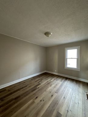Hopkinsville house for rent - an empty living room with wooden floors and a window