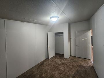 Jones house for rent - a bedroom with white closets and a carpeted floor and a door to a