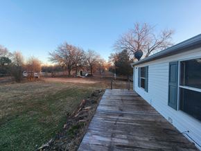 Jones house for rent - a view of the side of a house with a wooden walkway