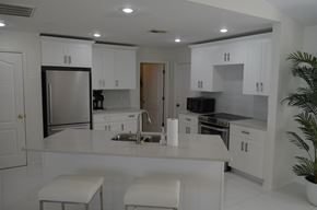 Cape Coral house for rent - a kitchen with white cabinets and a counter top