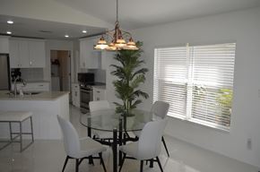 Cape Coral house for rent - a dining room with a glass table and white chairs