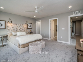 Waukee apartment for rent - A bedroom with a large bed and a ceiling fan.