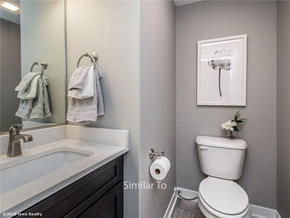Waukee apartment for rent - A bathroom with a toilet, sink, and mirror.