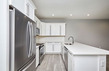 Waukee apartment for rent - A modern kitchen with white cabinets and a stainless steel refrigerator.