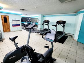 Edmonton apartment for rent - a gym with various exercise equipment in a room with a tile floor