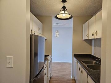 Edmonton apartment for rent - a kitchen with stainless steel appliances and white cabinets