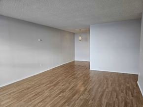 Edmonton apartment for rent - an empty living room with wood floors and white walls