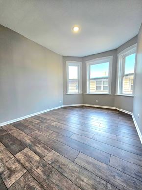 Chicago apartment for rent - A room with a wooden floor and a window.