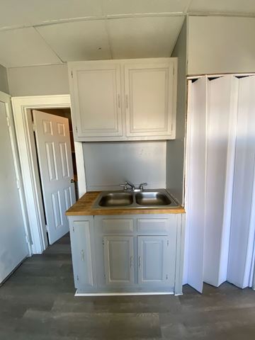 Cincinnati apartment for rent - A kitchen with white cabinets and a wooden countertop.