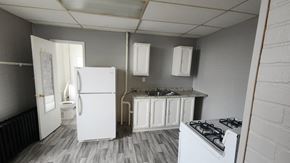 Cincinnati apartment for rent - A small kitchen with a refrigerator, stove, and sink.