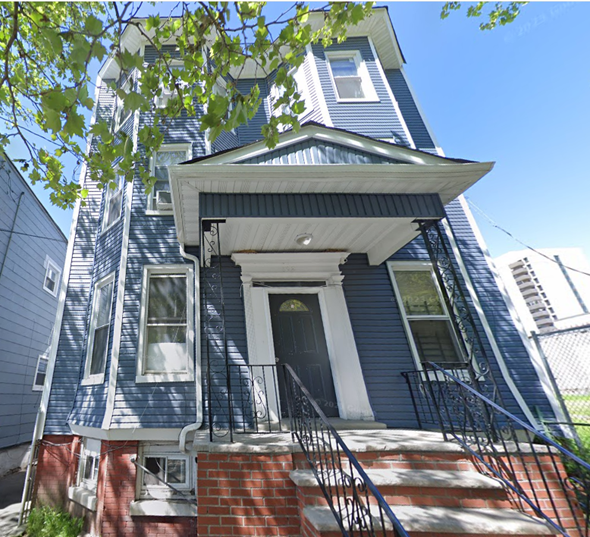 Jersey City apartment for rent - the front of a blue house with stairs and a roof