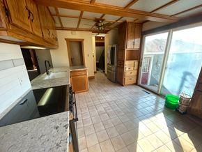 Pine Island house for rent - an empty kitchen with tile flooring and a sliding glass door