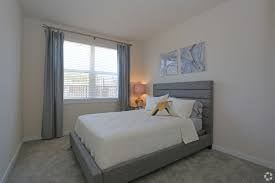 Tampa apartment for rent - A bedroom with a large bed and a window with curtains.
