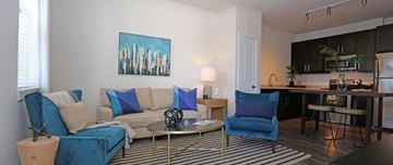 Tampa apartment for rent - A living room with a blue couch and a painting on the wall.