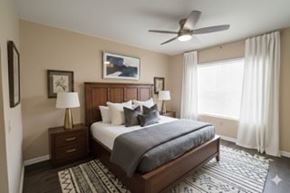 Tampa apartment for rent - A bedroom with a bed, nightstands, and a ceiling fan.