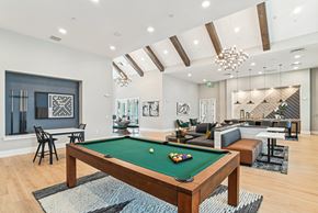 Charlotte apartment for rent - A pool table is in the middle of a room with a couch and chairs.
