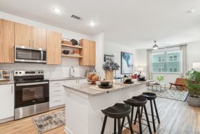 Charlotte apartment for rent - A kitchen with a white counter top and wooden cabinets.