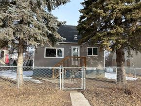 Prince Albert house for rent - A house with a grey roof and a fence with a gate in front of it.